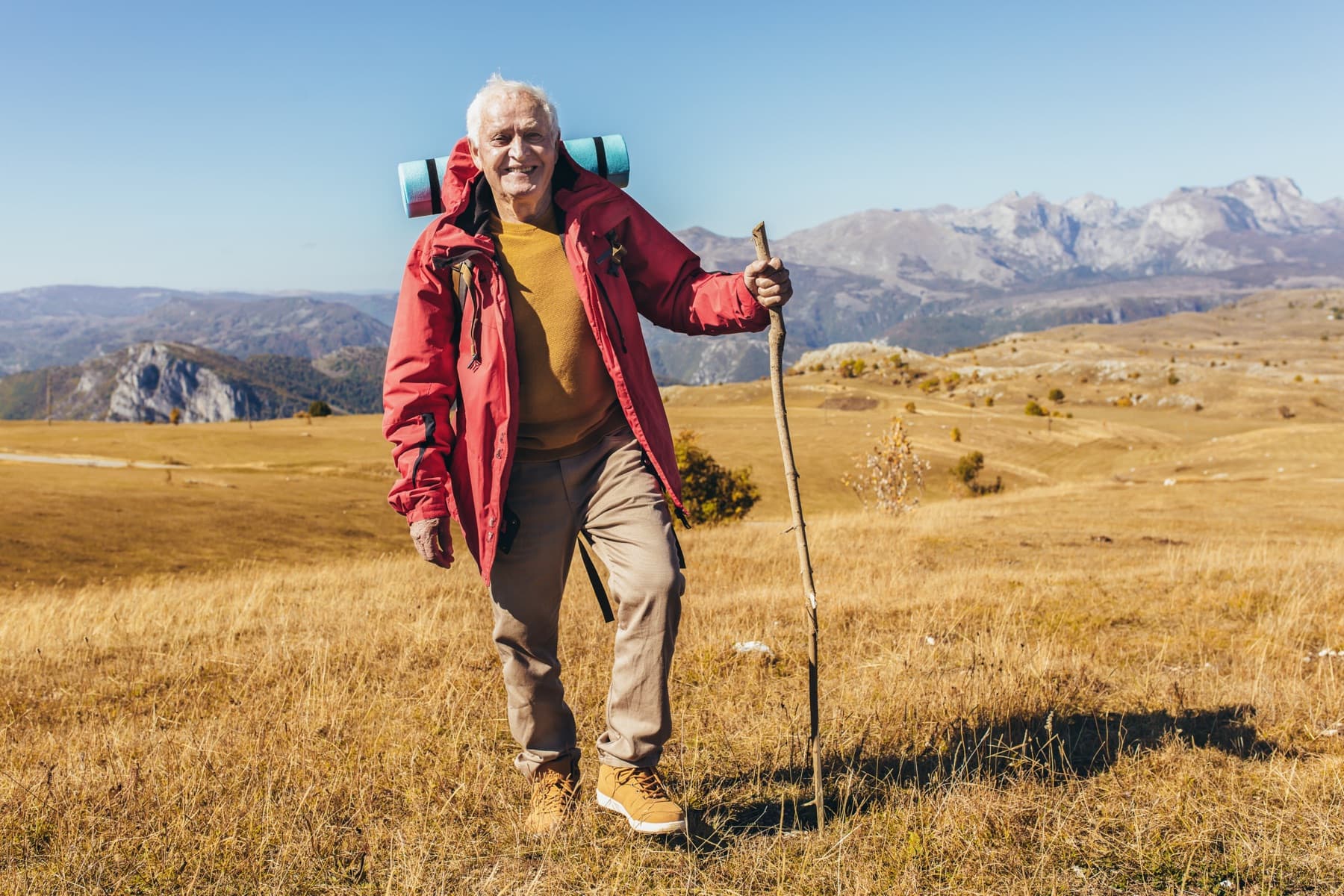 Active older man hiking in the mountains, healthy and energized